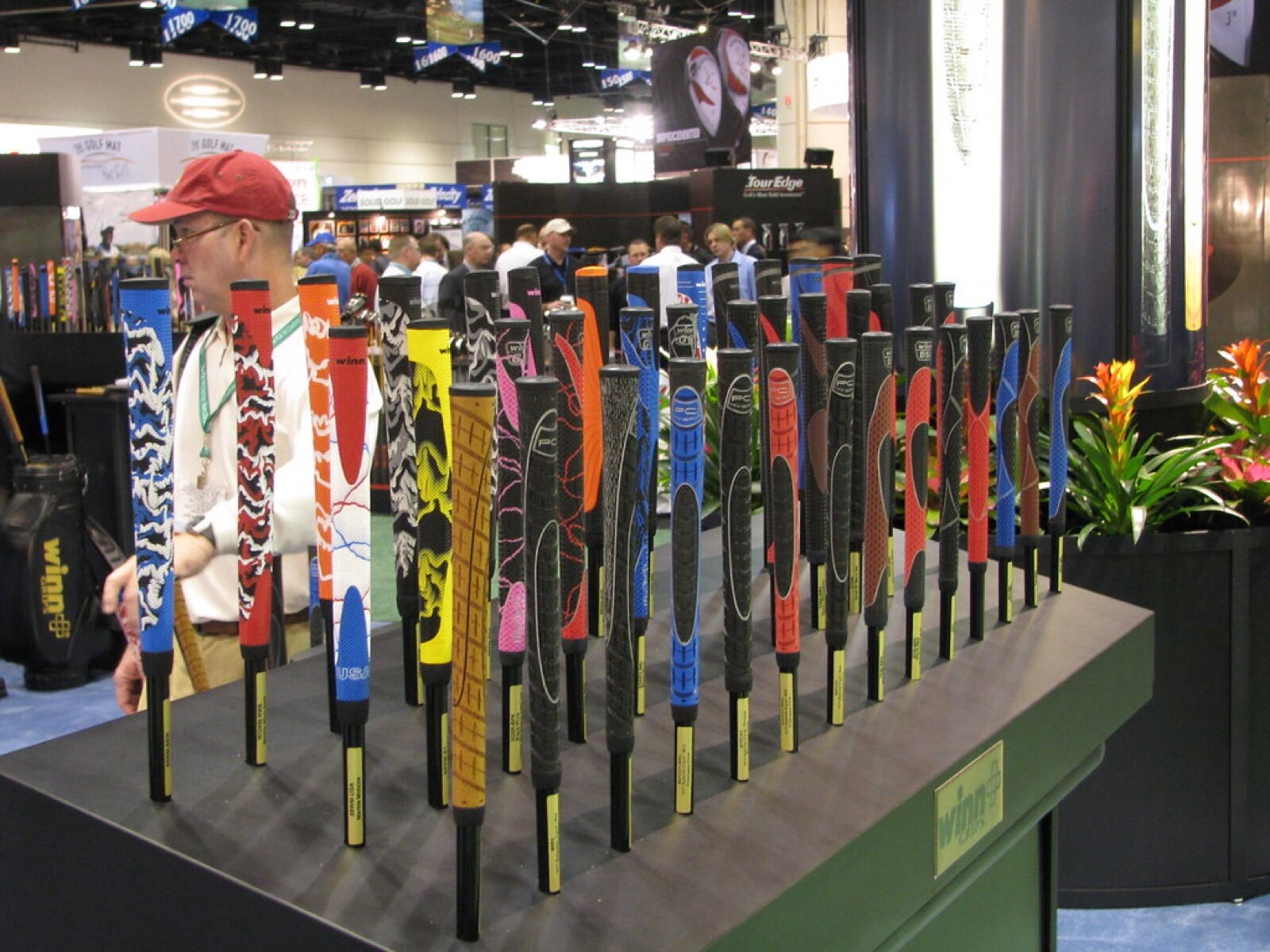 Rows of colourful golf club grips standing upright on a display stand at a trade show