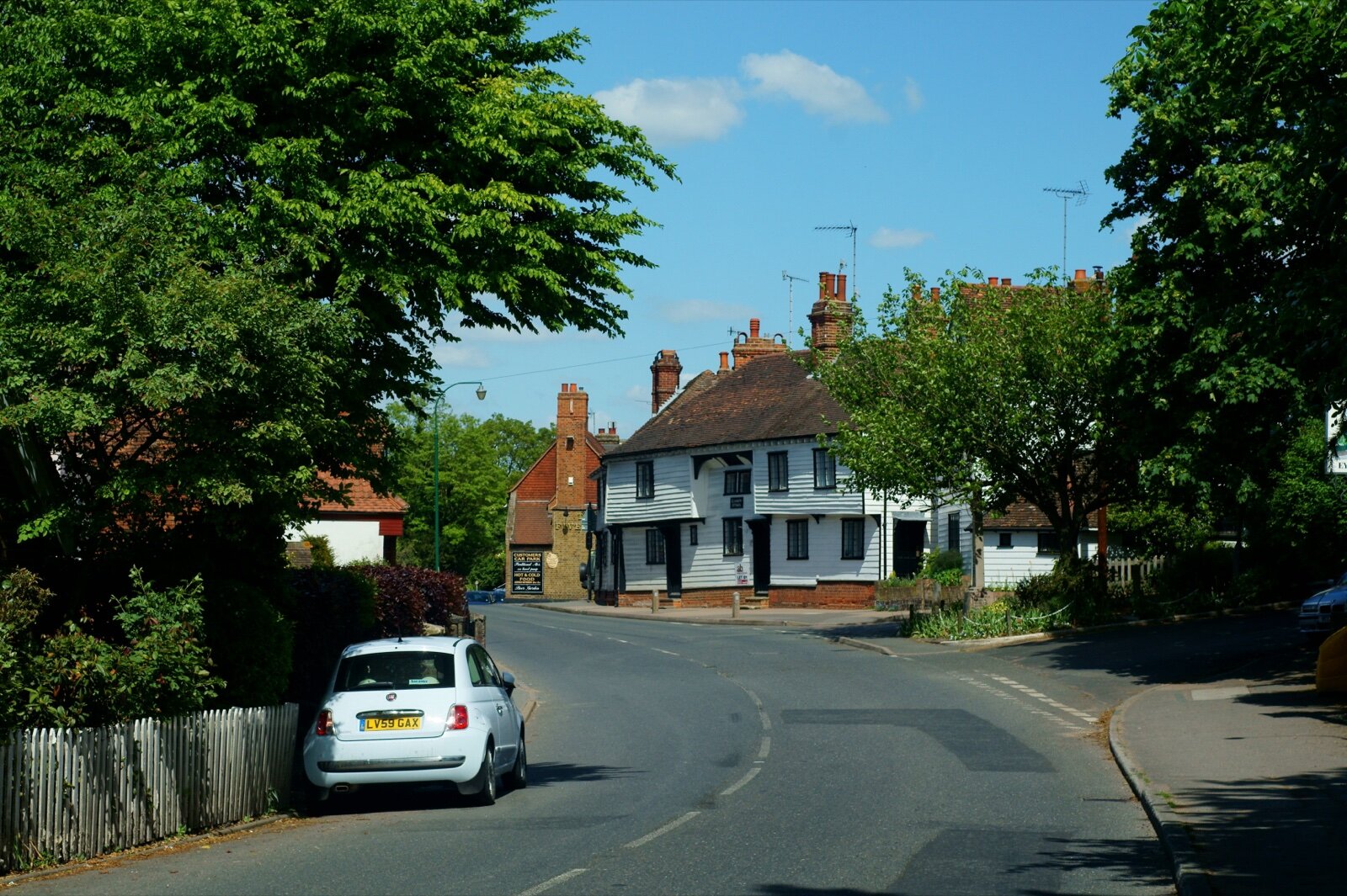 High Street in Eynsford, Kent, with weatherboarded buildings and a pub sign